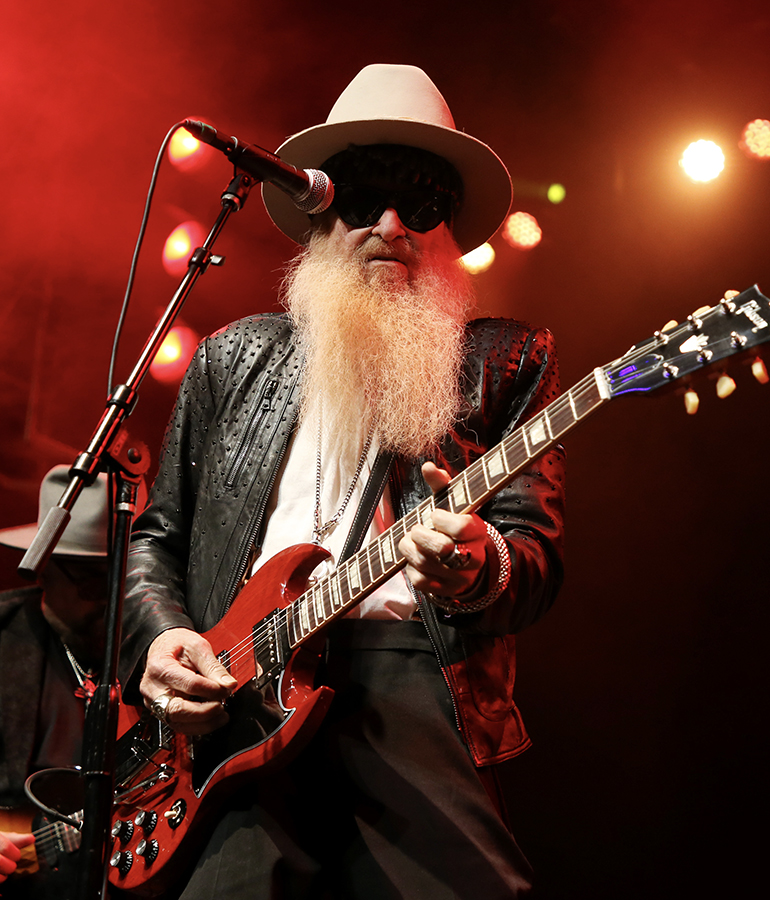 Billy F. Gibbons of ZZ Top performing onstage with red guitar