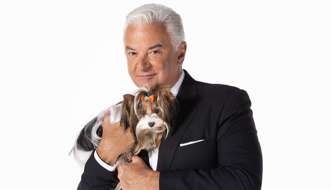 John O’Hurley, host of the The National Dog Show, posing with a Biewer Terrier 