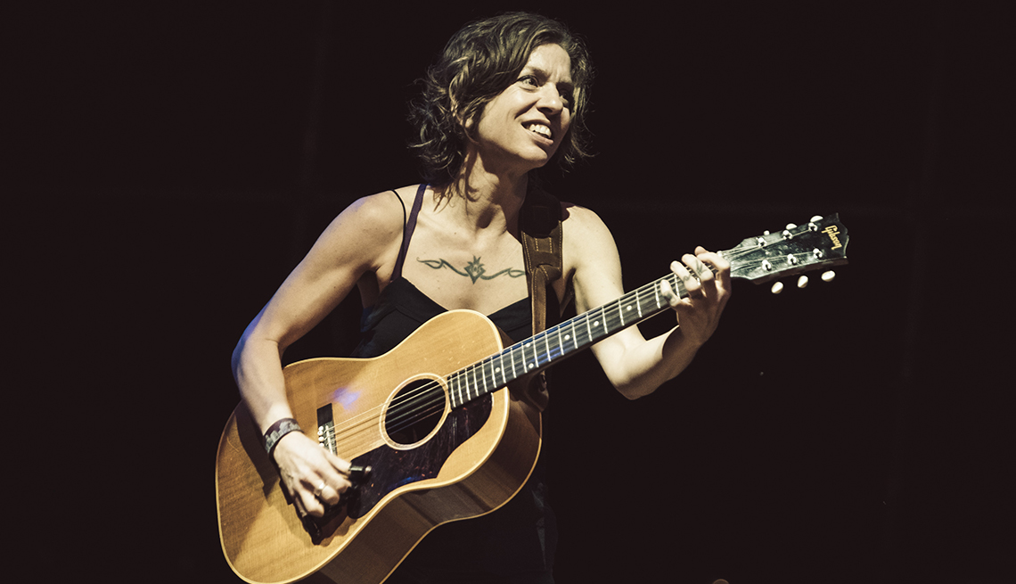 Ani DiFranco playing acoustic guitar