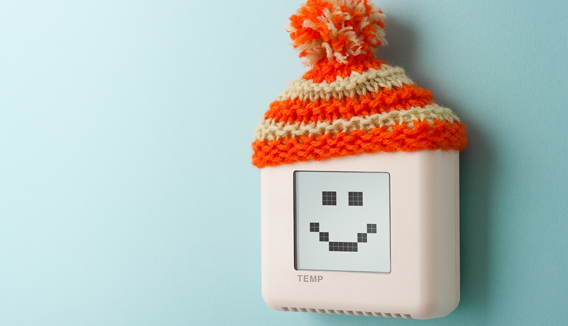 thermostat with a smiley face wearing a knitted winter hat with pom pom