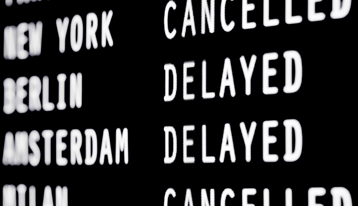 airplane flight schedule board showing "cancelled" and "delayed" flights