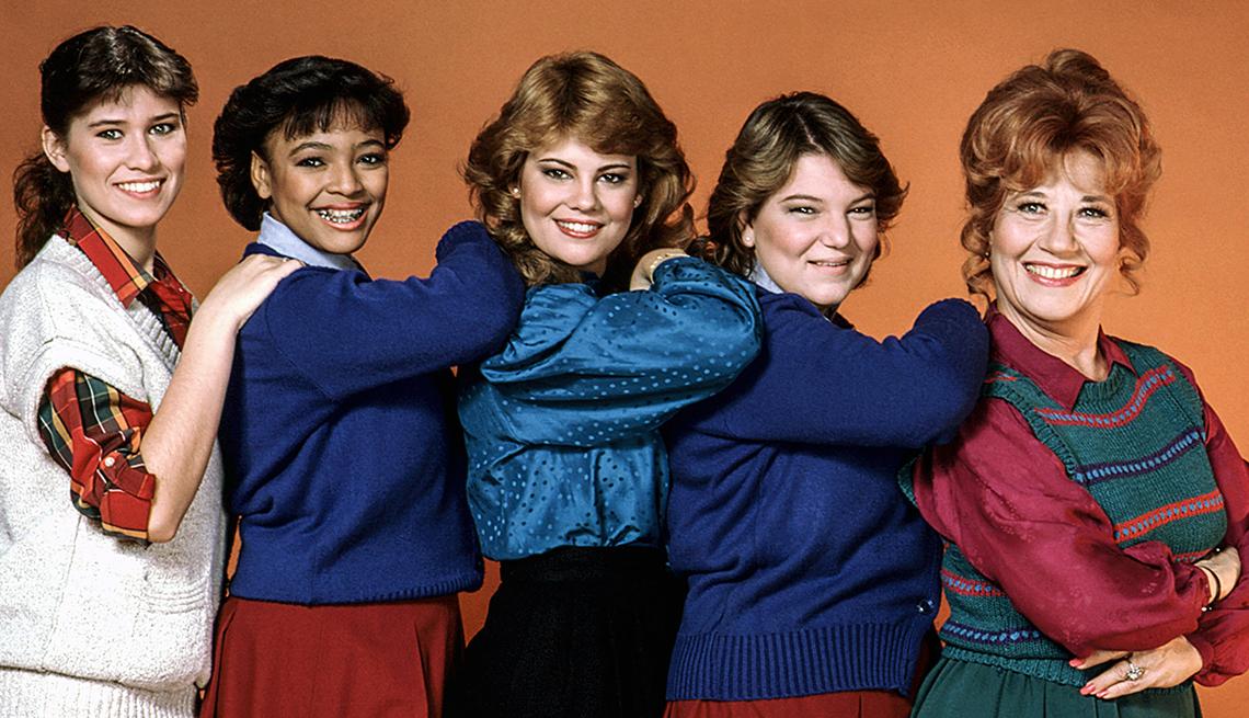TV actresses Nancy McKeon, Kim Fields, Lisa Whelchel, Mindy Cohn, Charlotte Rae, (Season 5, 1984) pose in front ofa brown background