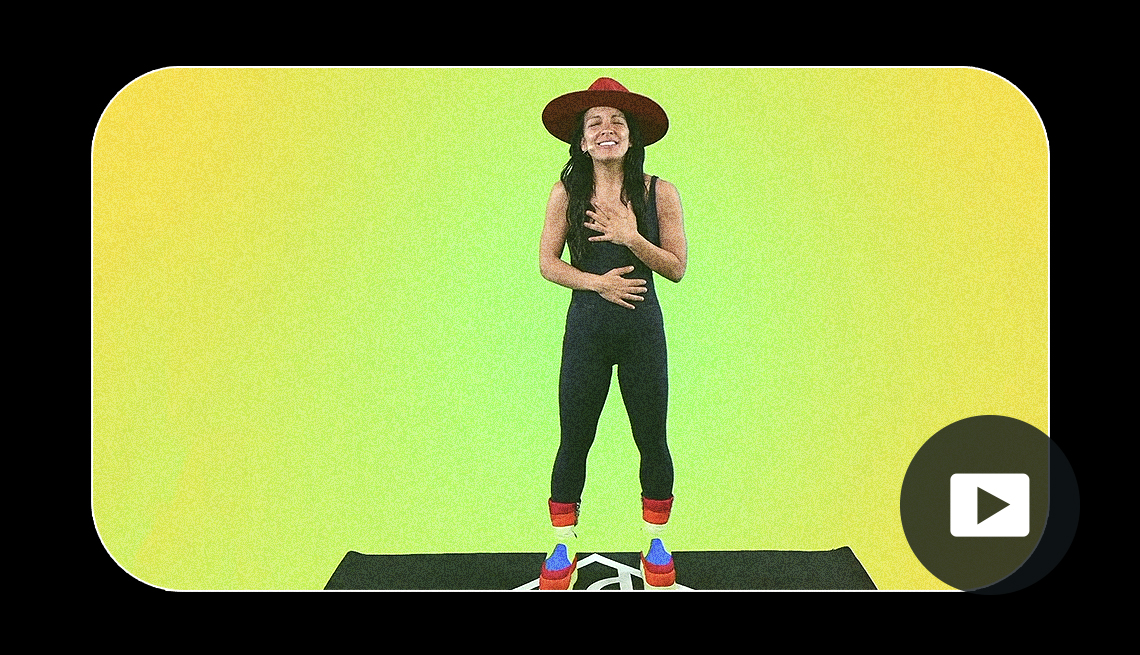 Daybreaker presenter Radha Agrawal stands on a yoga mat in front of a green screen. Video play button in lower right corner.