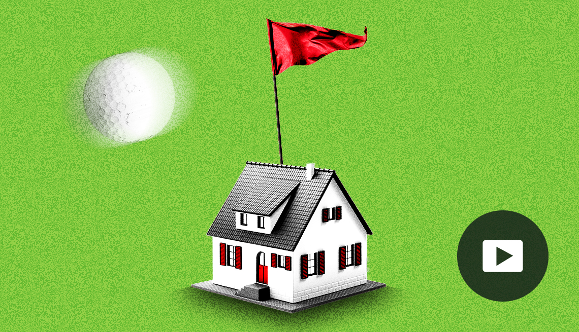 A giant golf ball flies past a small house illustration with a red flag sticking out of the roof, all on a green background. Video play button in lower right corner.