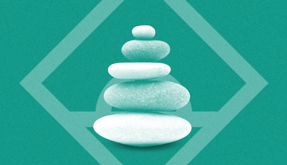 A stack of round stones in front of a square graphic shape on a solid green background