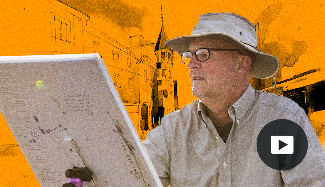 Stan Fellows painting at an easel with an orange background showing a watercolor illustration of a building. Video player icon in lower right corner.