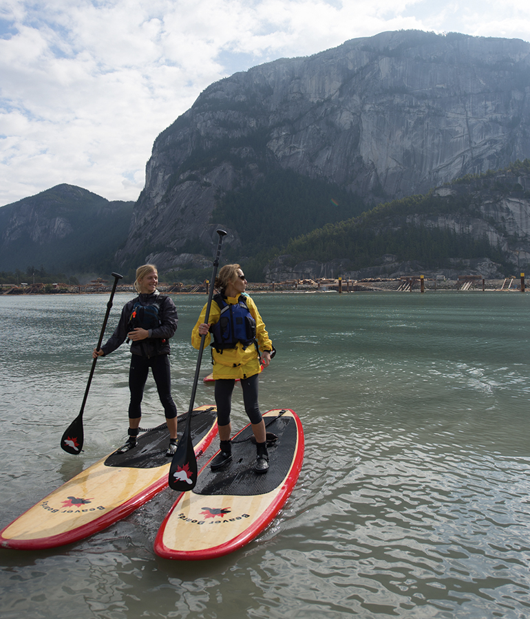Two people go paddle boarding in British Columbia