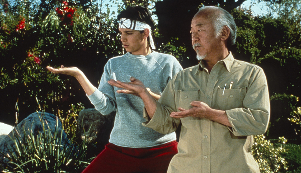 ralph macchio as daniel larusso and pat morita as mister miyagi doing karate moves in a still from the karate kid 3