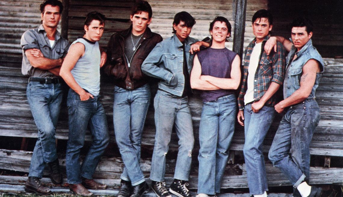 patrick swayze, emilio estevez, matt dillon, ralph macchio, c thomas howell, rob lowe and tom cruise standing against wall in a still from the outsiders