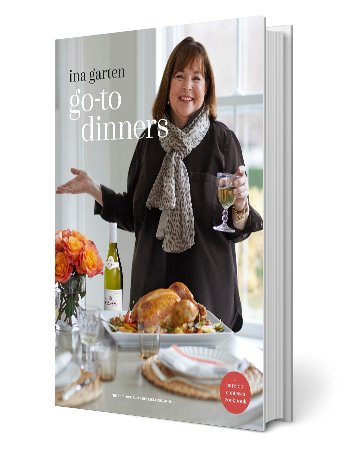 ina garten on book cover of go-to dinners, holding glass of white wine; table has flowers, bottle of wine, turkey, paper plates, and glasses
