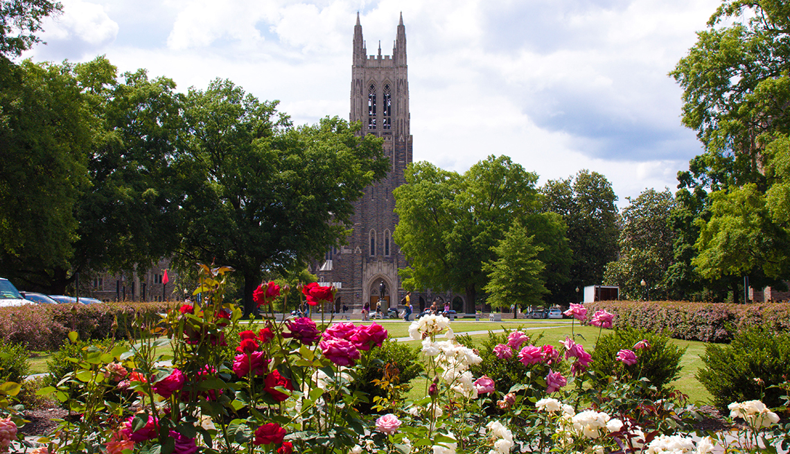 duke university chapel with trees surrounding it and flowers in front