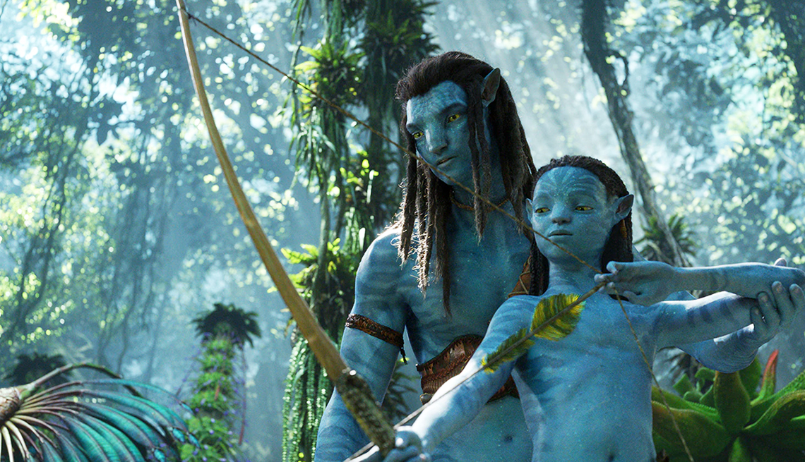 two characters in wilderness, one shooting a bow and arrow in a still from avatar the way of water