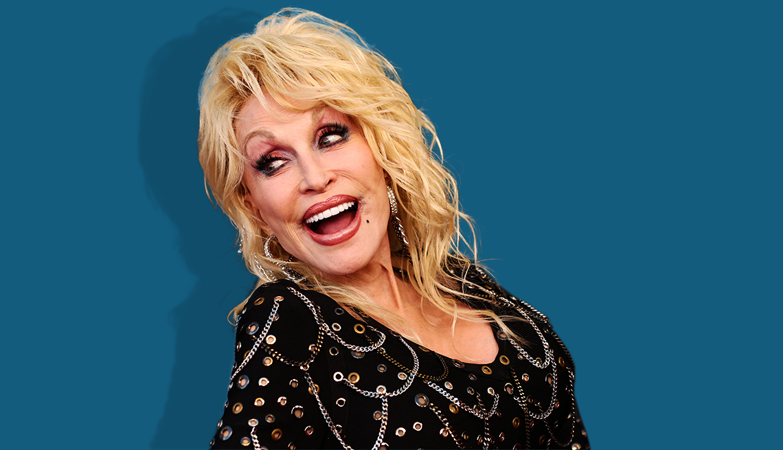 dolly parton smiling big against blue background