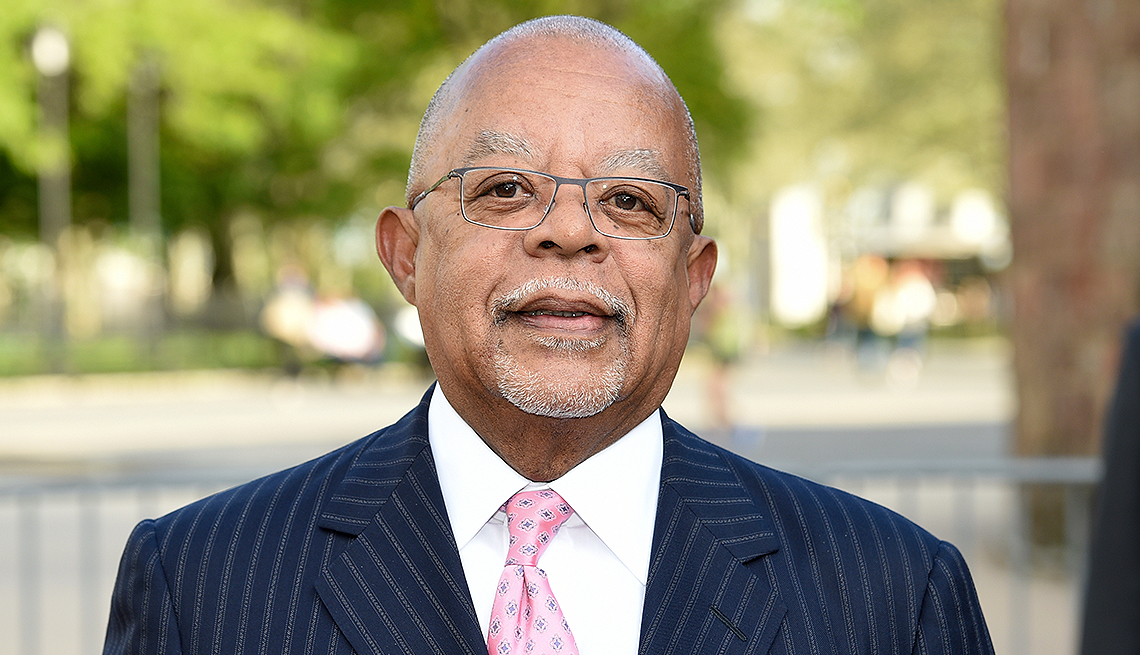 henry louis gates outside; blurred background of trees and road