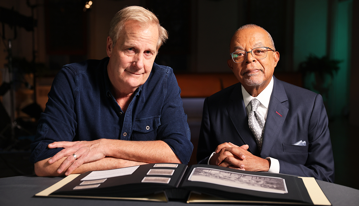 jeff daniels and henry louis gates sitting at table with photo album in front of them