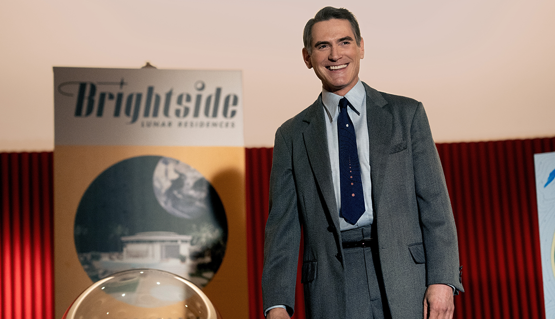 billy crudup standing next to sign that says brightside lunar residences
