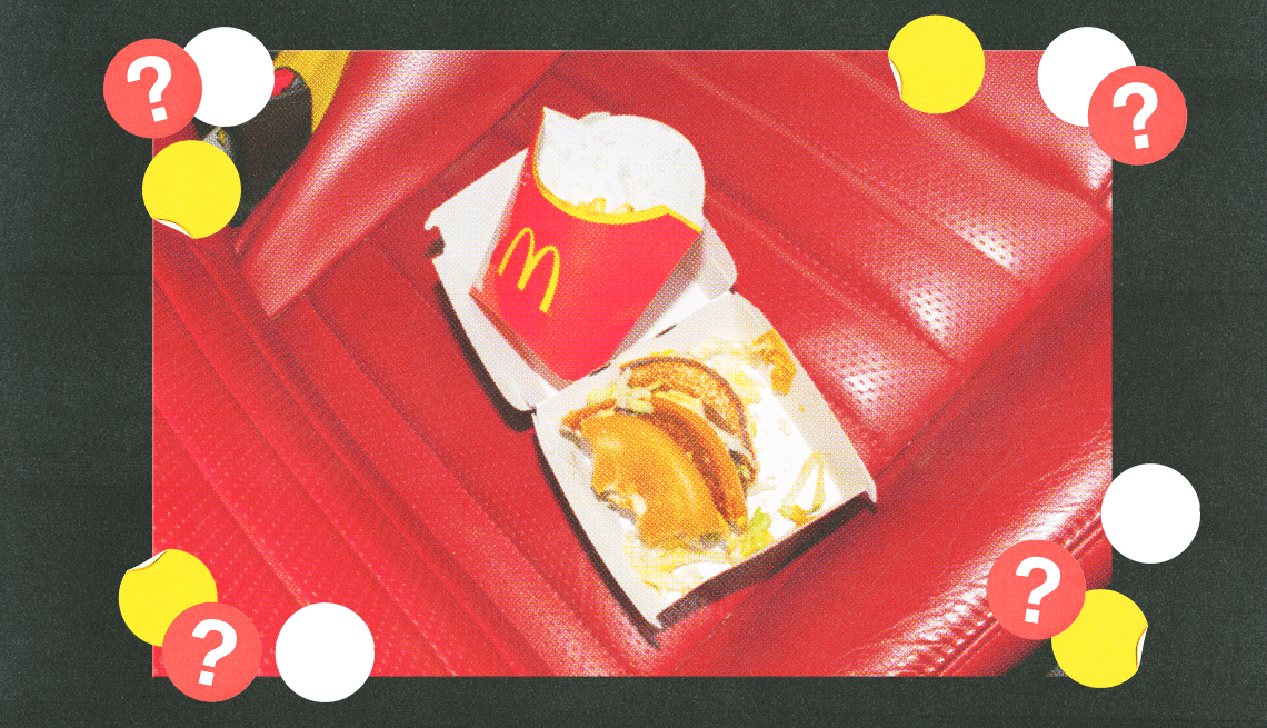 mcdonalds half eaten burger and half empty fry container in open burger box on red seat surrounded by yellow, white and red circles with question marks