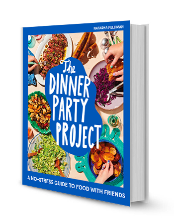 book that reads the dinner party project on the cover, surrounded by a variety of different foods