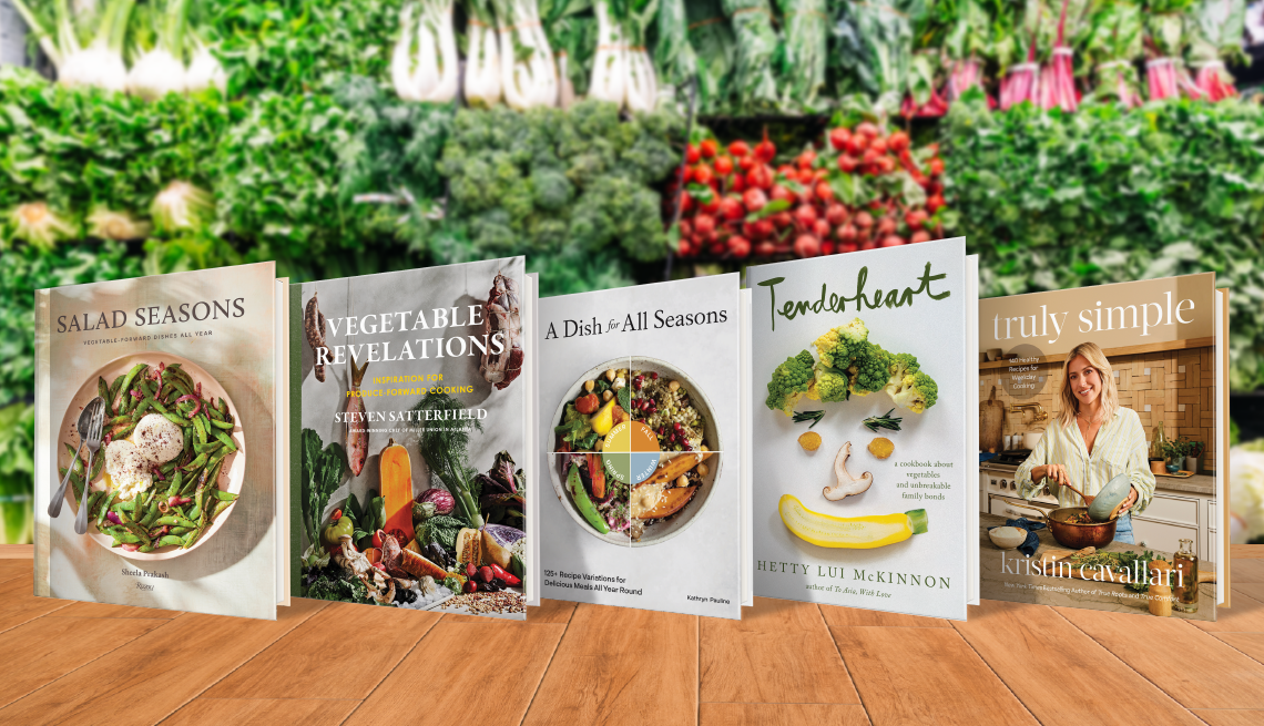 Five books on wooden table with vegetables and plants behind them