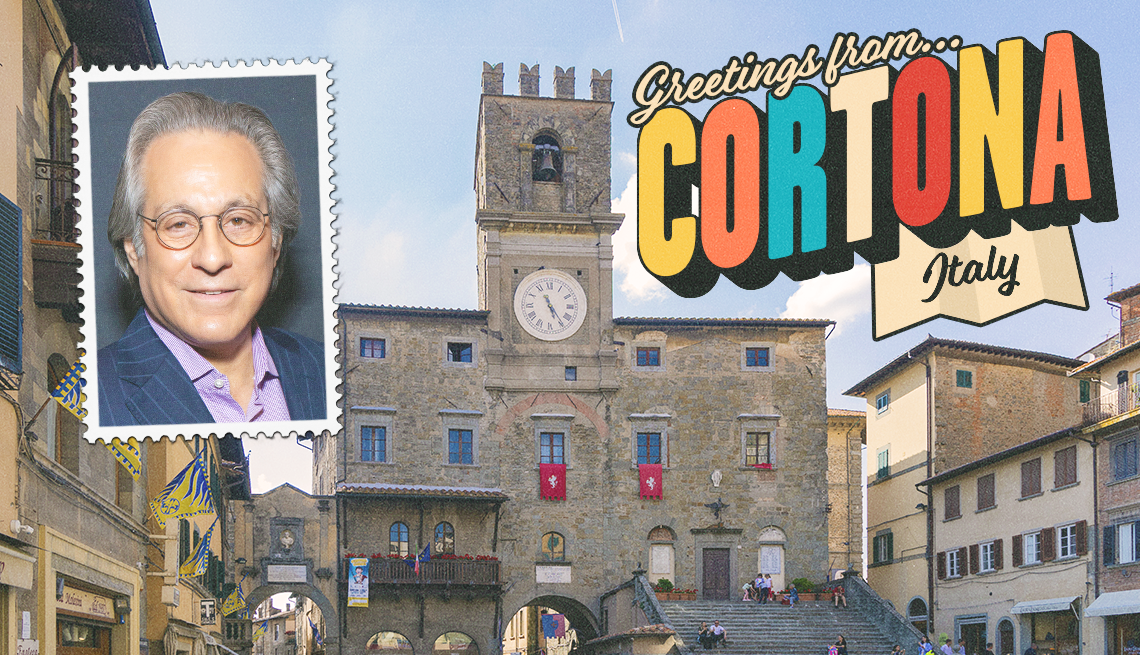 Buildings in Cortona, Italy as background; photo of Max Weinberg in upper left corner; the words greetings from Cortana, Italy in upper right corner