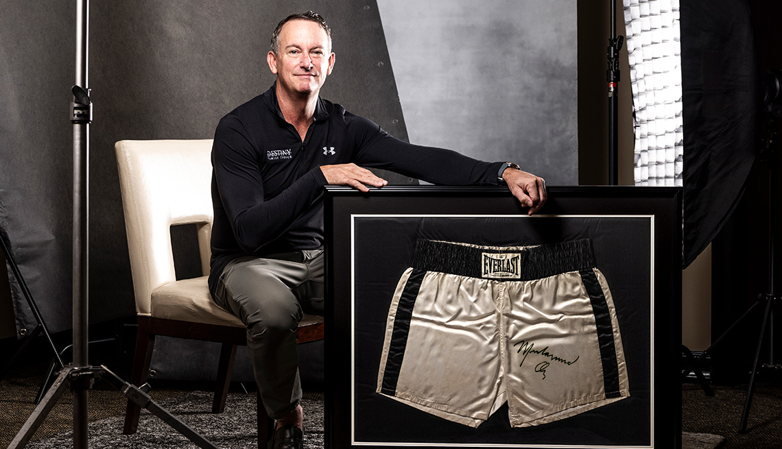 Thomas Ruggie with framed boxing trunks that were﻿ worn by Muhammad Ali