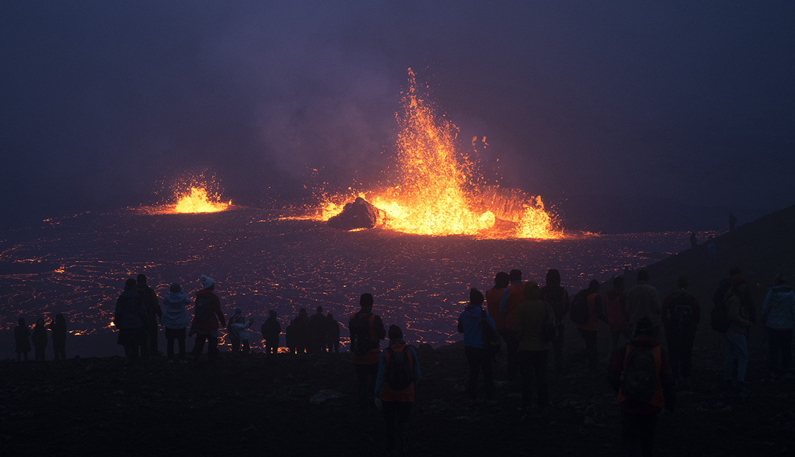 People watch lava burst from a newly erupted volcano Aug. 6 near Iceland’s Keflavik Airport