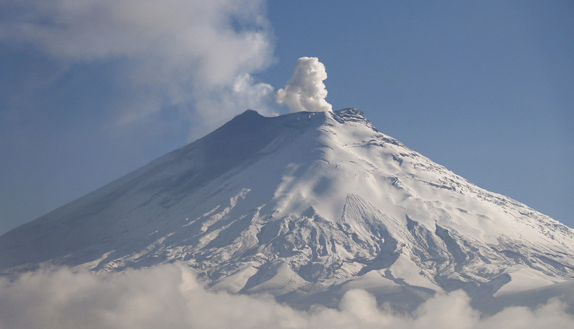 item 14 of Gallery image - snow-covered cotopaxi volcano emits ash and gas against a blue sky