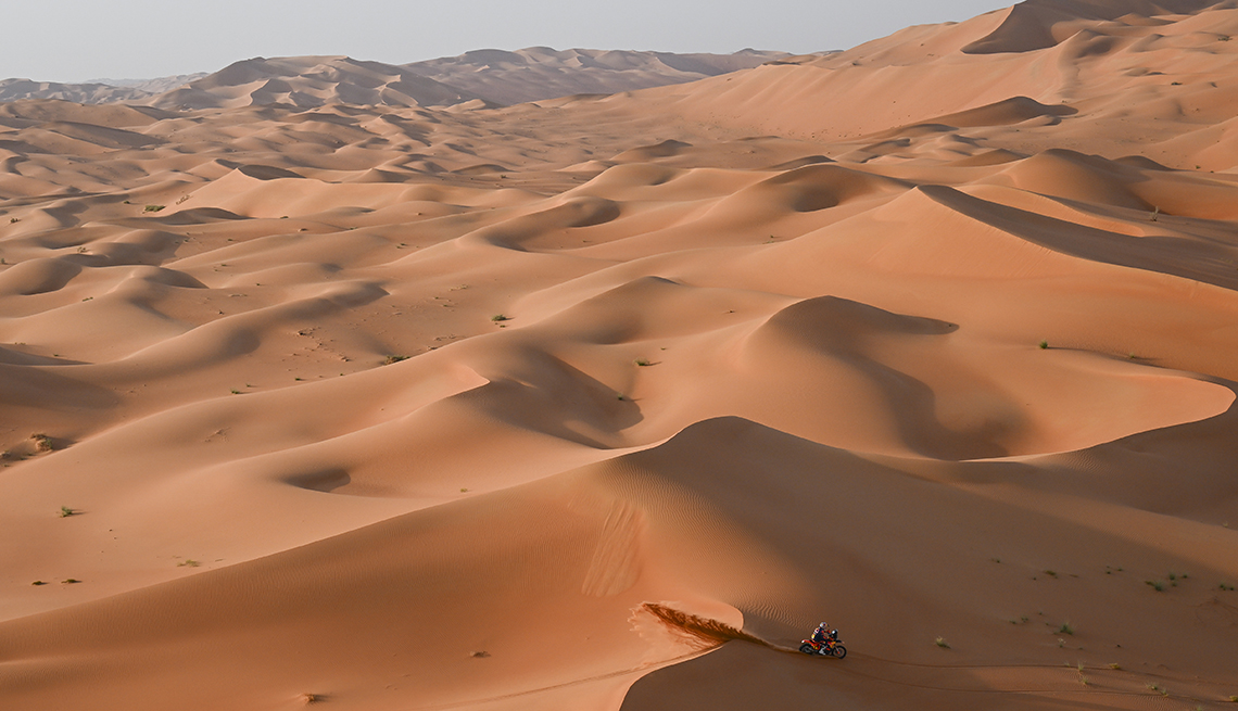 item 8 of Gallery image - a motorbike is being raced across a hilly expanse of desert