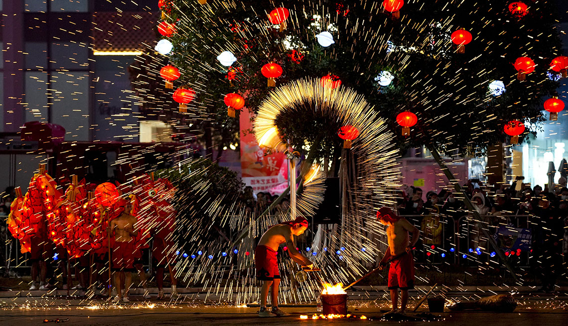 performers of a fire dragon dance shower molten iron in sparkler-like fireworks against the night sky