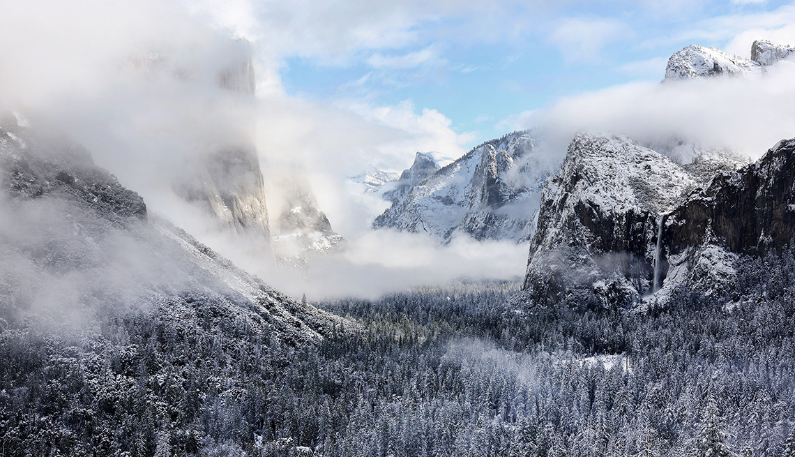 item 6 of Gallery image - snow-topped mountain peaks and trees of yosemite under white clouds and blue sky   