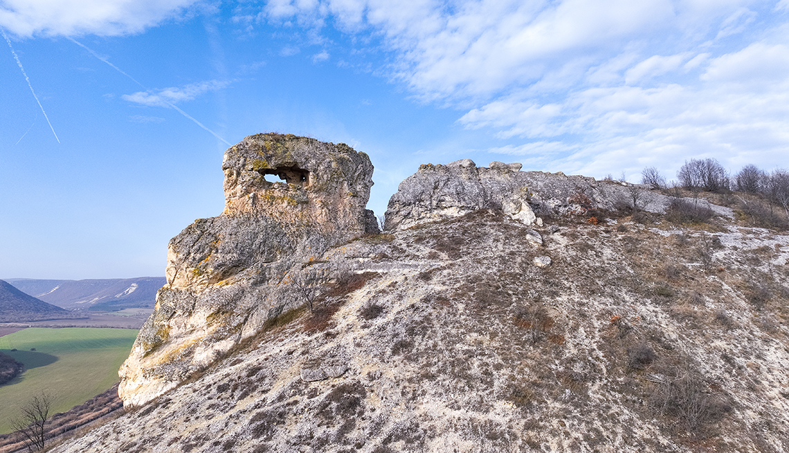 item 2 of Gallery image - the stone with a hole in venchan, bulgaria against a blue sky with clouds  