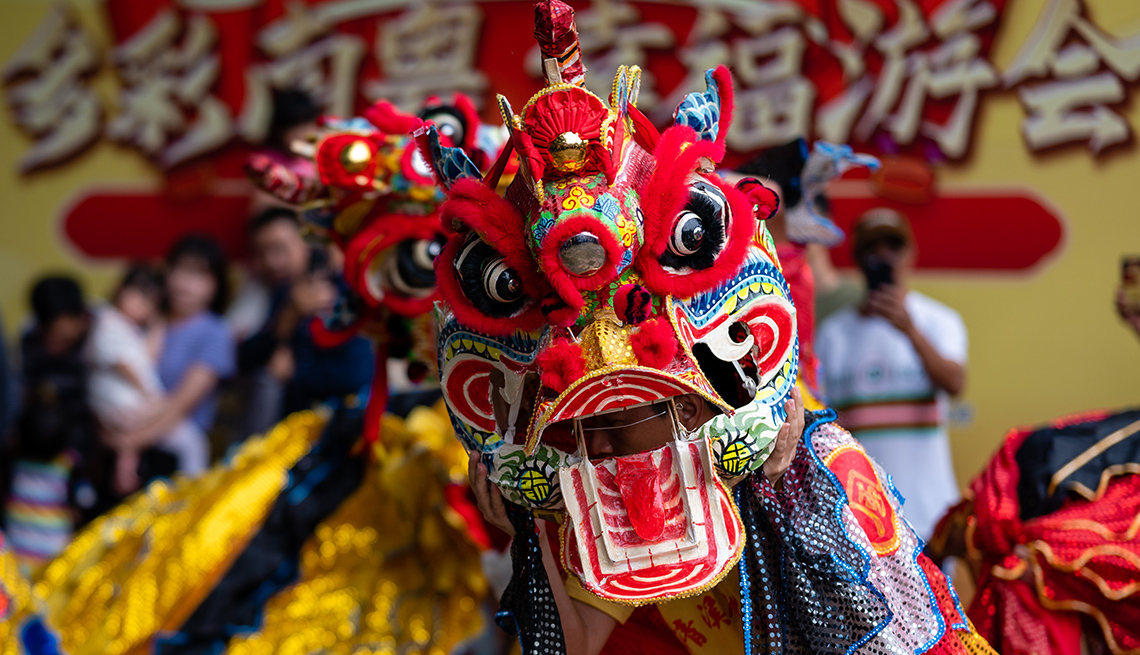 item 3 of Gallery image - close-up of performer in a dancing lion costume  with onlookers in the background at a carnival in china