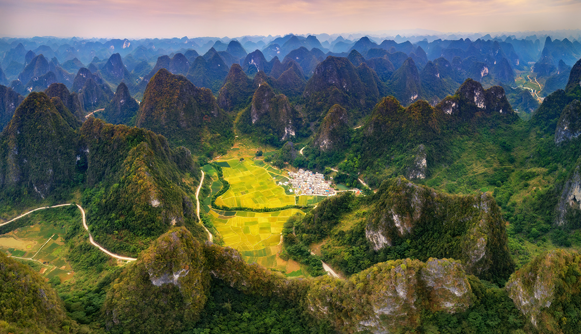 item 1 of Gallery image - breathtaking aerial view of seemingly endless karst mountains surrounding bright yellow and green fields in a valley
