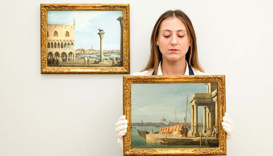 item 8 of Gallery image - A Sotheby’s representative displays the artwork 'Venice … ' by the Italian painter Giovanni Antonio Canal, commonly known as Canaletto