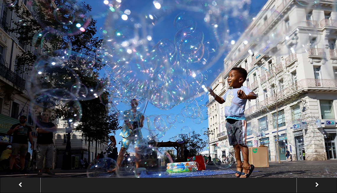 A child plays with bubbles from a street performer at the Old Port of Marseille, France.