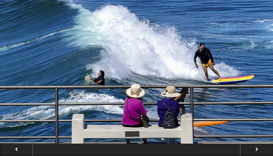 Visitors watch surfers in Huntington Beach, California.