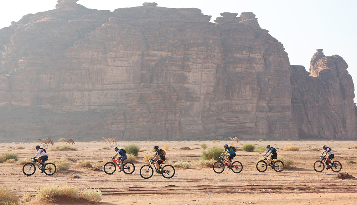 item 2 of Gallery image - Athletes cycle past camels on during the NEOM Beach Games 2023 in Neom, Saudi Arabia. 