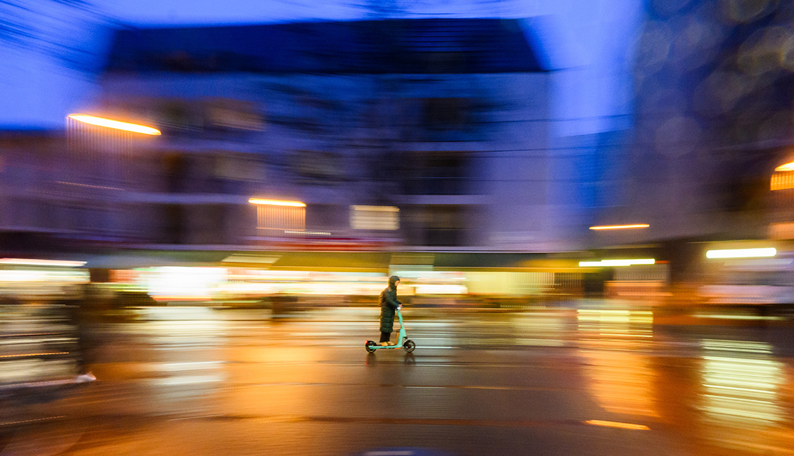 item 14 of Gallery image - A woman rides an electric scooter along Limmerstraße in the early morning in Lower Saxony, Hannover, Germany. 