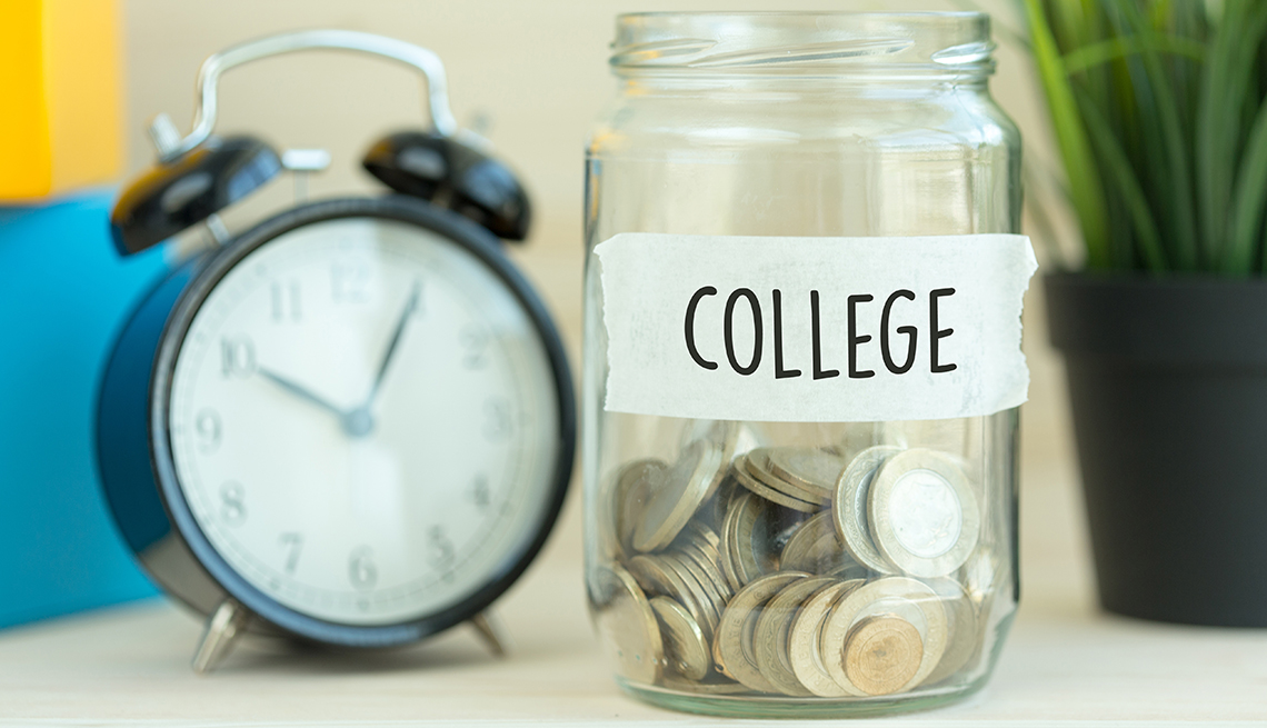 Reloj al lado de una jarra con monedas y un letrero que dice universidad en inglés