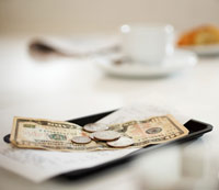dollar bills and coins on tip tray