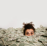 Studio shot of woman up to her eyes in money