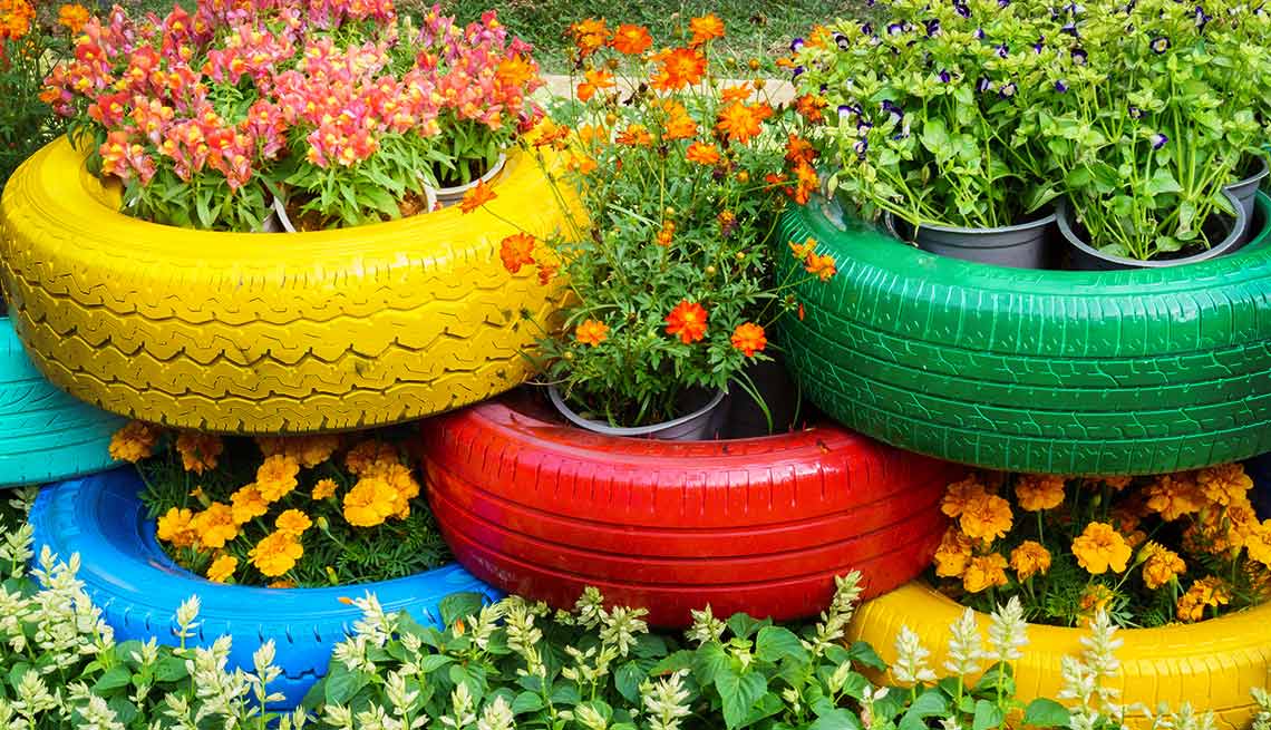 Llantas viejas de automóvil pintadas que pueden usarse para la jardinería en el patio de tu casa como reciclaje mejorado