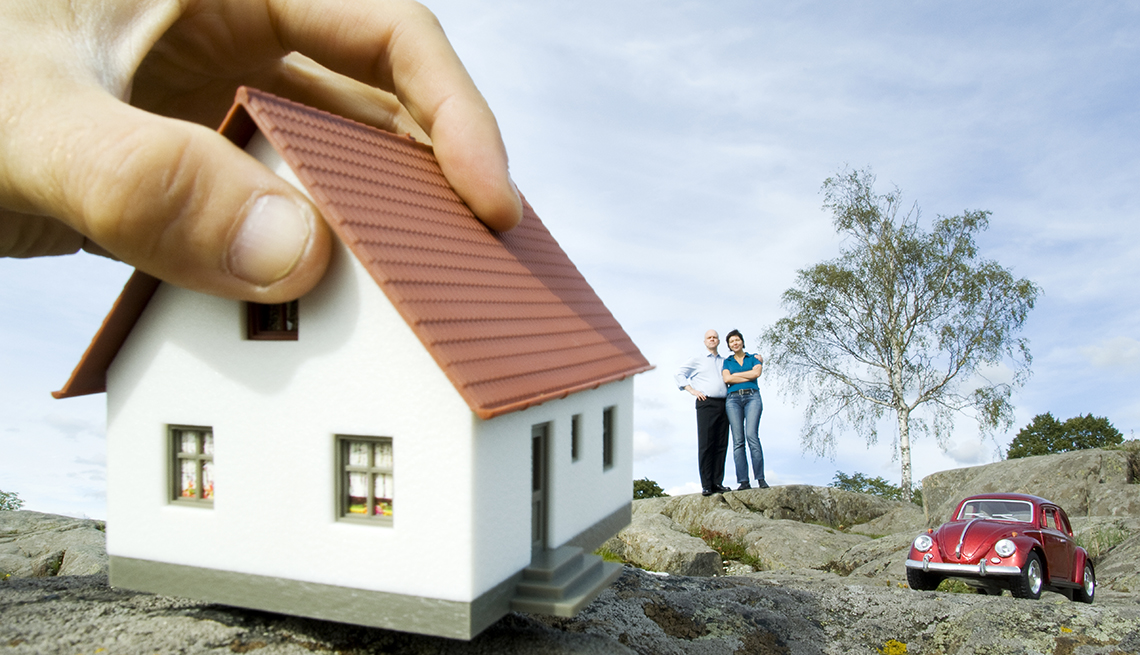 Montaje de una mano agarrando una vivienda y consejos para comprar casa 