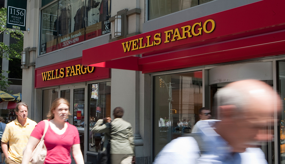 Personas caminando frente a una sucursal de Wells Fargo.