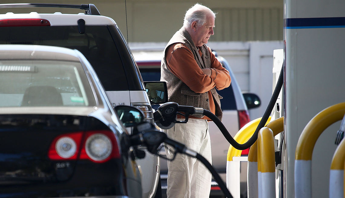 Persona colocando combustible a su auto en una estación de gasolina