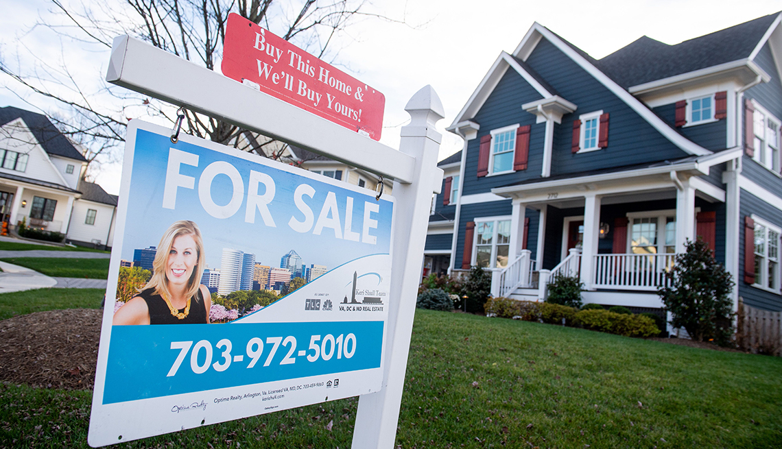 The real estate for sale sign of a house is seen in front of a house in Arlington, Virginia on November 19, 2020. 