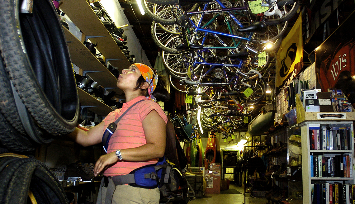 A shopper stands under display of bikes on ceiling at a sporting goods consignment store in Boulder, Colorado.