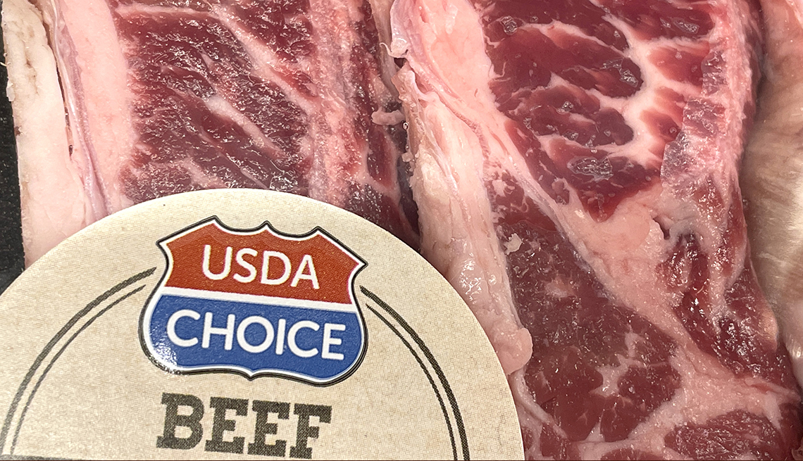 closeup of a package of steak with a sticker that certifies it as u s d a beef