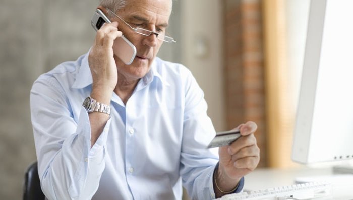 Un hombre llamando por teléfono a las compañias de tarjetas de crédito