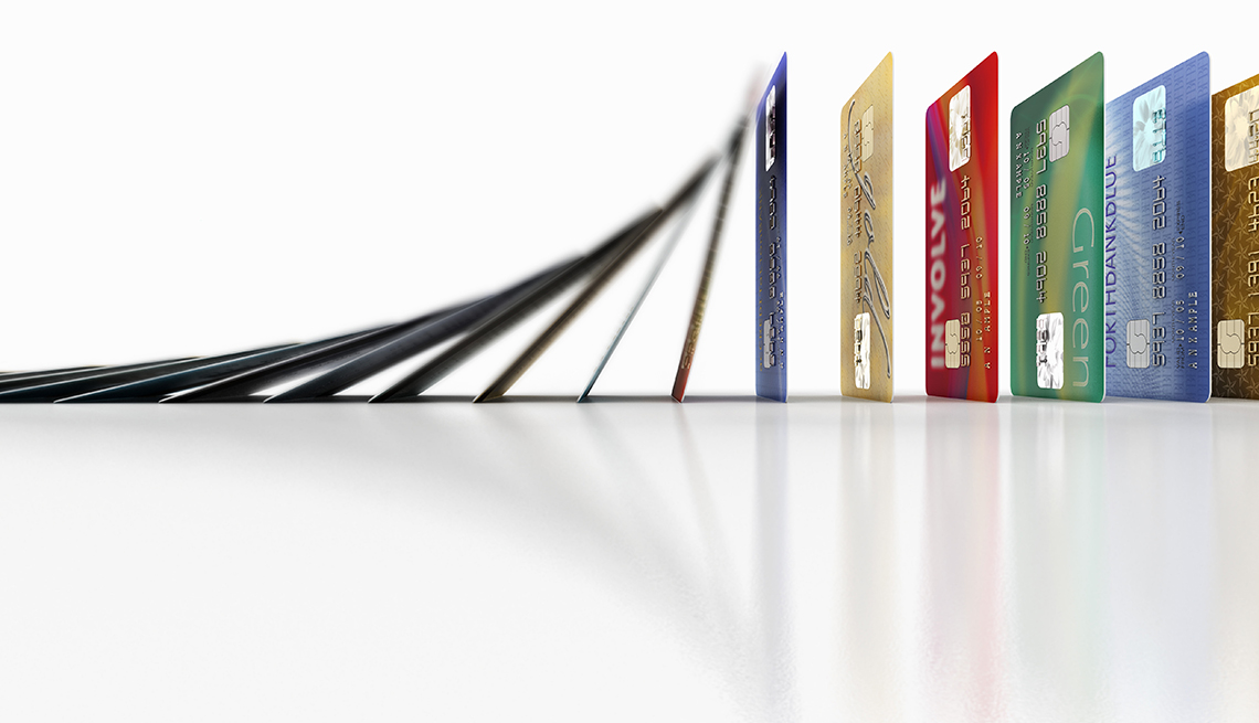 Fila de tarjetas de crédito cayendo como piezas de domino y aprende a mejorar tu puntaje crediticio